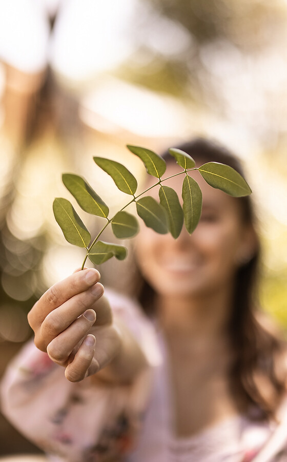 Donna nel giardino dell’hotel che tiene una foglia in mano
