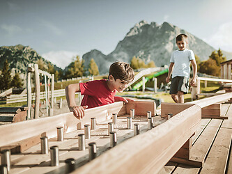 Ragazzi che giocano con la pista delle biglie a Merano 2000