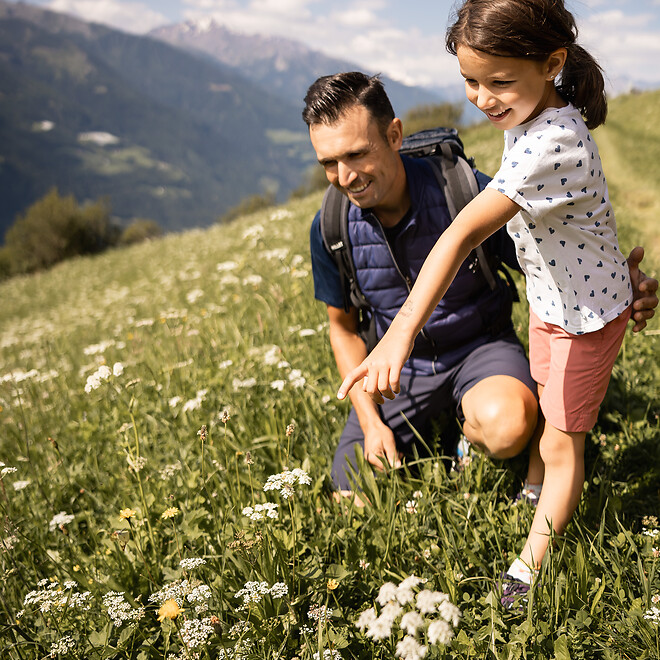 Famiglia su un prato in mezzo alle montagne