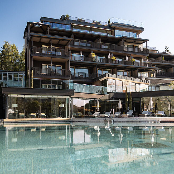 Facciata dell'hotel e piscina naturale nel giardino