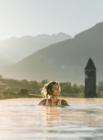 Frau im Sky Infinity Pool bei Sonnenaufgang