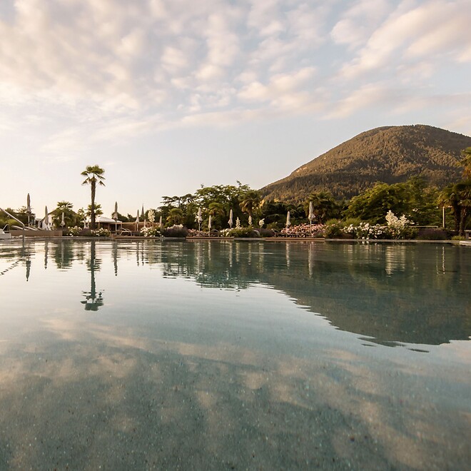 Piscina naturale nel giardino tra palme e montagne