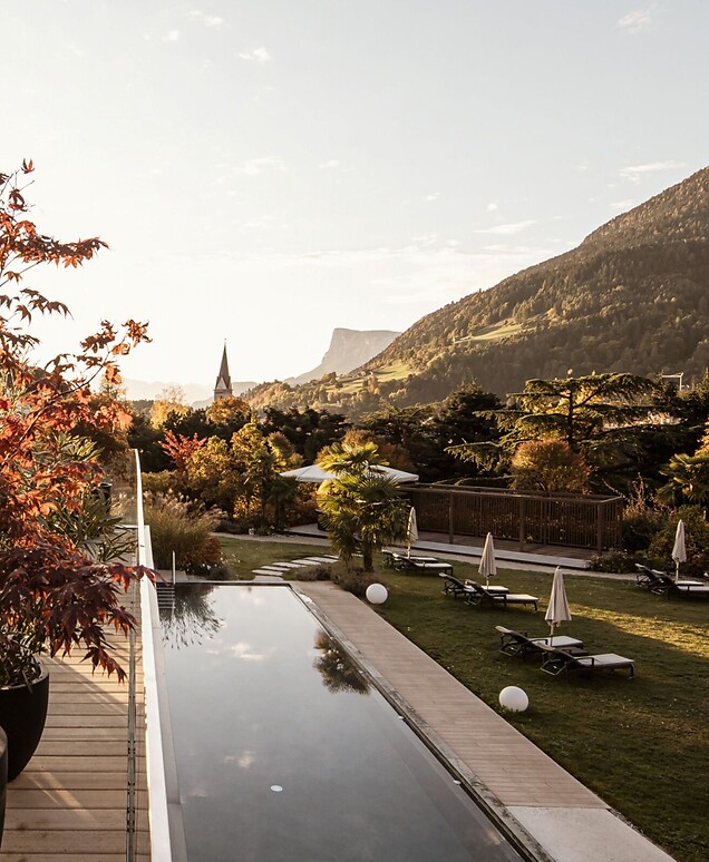 Piscina sportiva all’aperto nel giardino con paesaggio autunnale e panorama montano