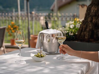 Ospite che gusta un bicchiere di Prosecco sulla terrazza soleggiata