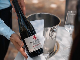 Il cameriere serve al cliente il vino della casa