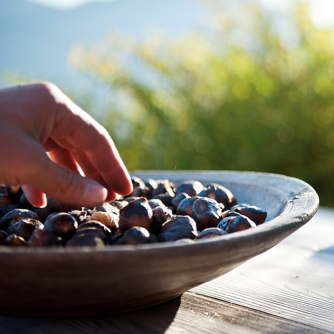 Ciotola con castagne e due bicchieri di vino rosso