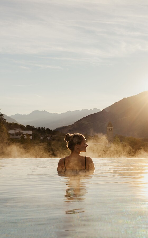 Donna nella Infinity Pool all'alba