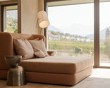 Sala relax con lettino arancione e vista sui frutteti e sulla chiesa di San Procolo