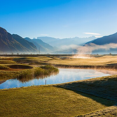 Campo da golf alla luce del mattino tra le Alpi