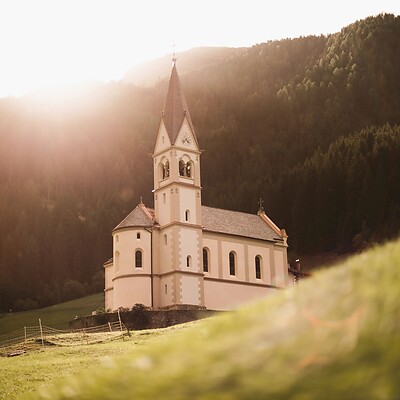 Chiesa in radura nel bosco in montagna al tramonto