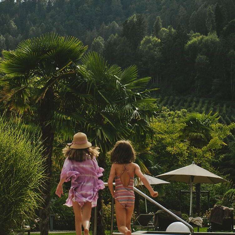 Kinder laufen durch den mediterranen Hotelgarten