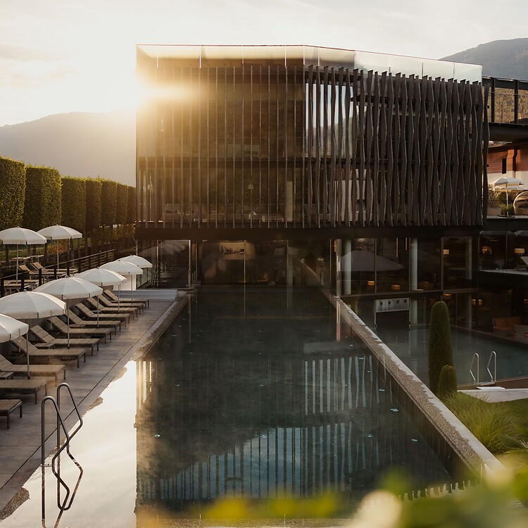 Wellnesstower mit Sportpool und Sonnenliegen bei Sonnenaufgang