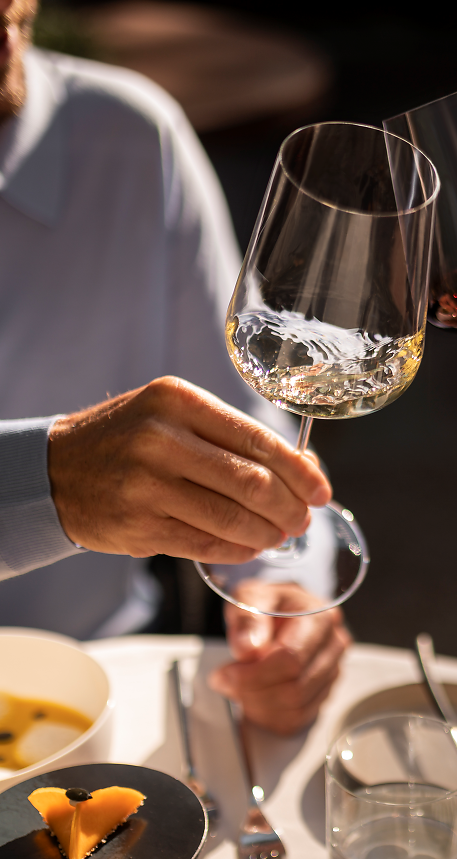 Mann und Frau genießen ein Glas Wein bei gutem Essen