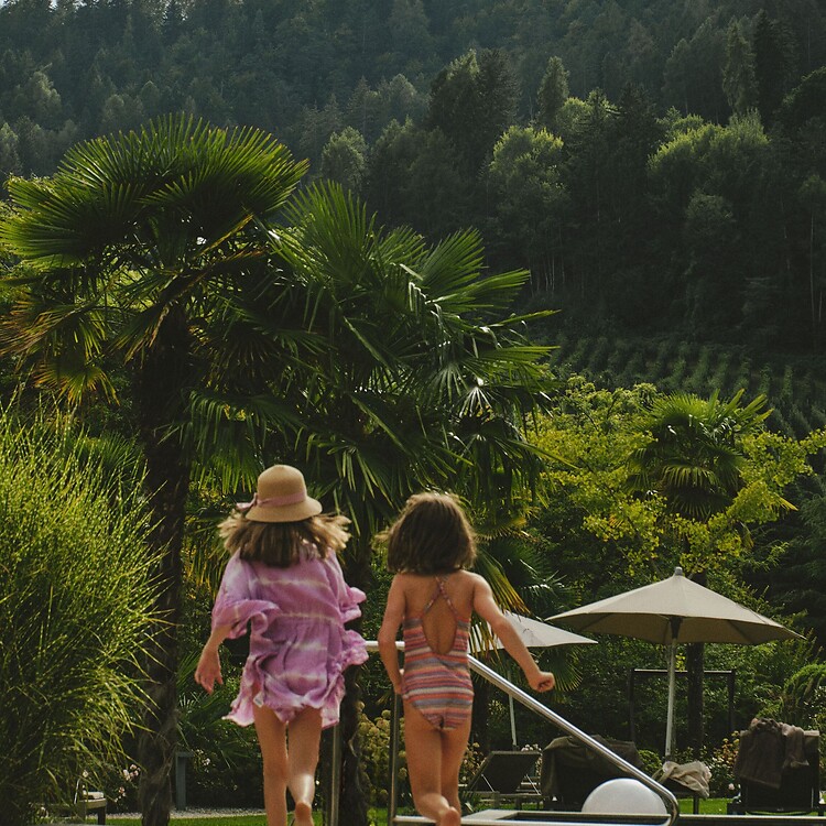 Bambini che corrono nel giardino mediterraneo dell'hotel