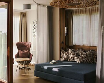 Day bed nella suite con balcone e vista sulla natura