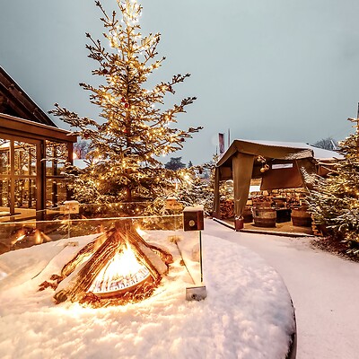 Alberi di Natale illuminati al mercatino con bancarelle di legno