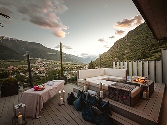 Terrazza decorata per esperienza spa privata per due con candele e camino