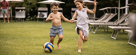Kinder spielen im Hotelgarten mit dem Ball