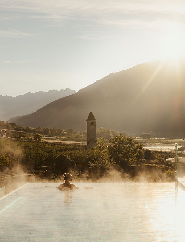 Woman enjoying the breathtaking view in the Infinity Skypool at sunrise