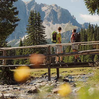 Two men hiking on trail near the Dolomites