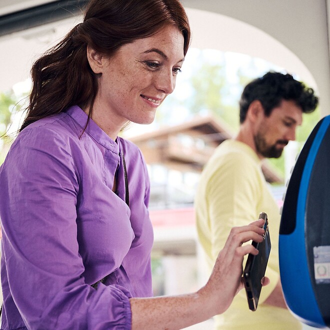 The woman scans the South Tyrol Guest Pass at the train station.