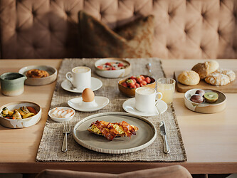 Set breakfast table with egg dishes, coffee, and fruit