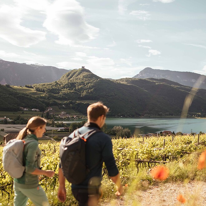 Woman and man on a spring hike past a lake with mountain views