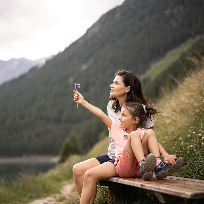 Mutter und Tochter ruhen sich auf Bank bei Bergwanderung aus