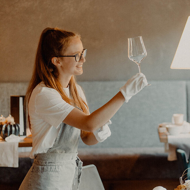 Servicekraft beim Aufdecken der Tische für das Abendessen
