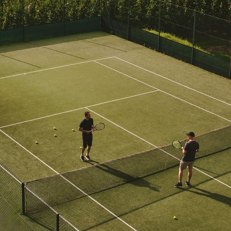 Campo da tennis privato dell'hotel circondato dalle montagne