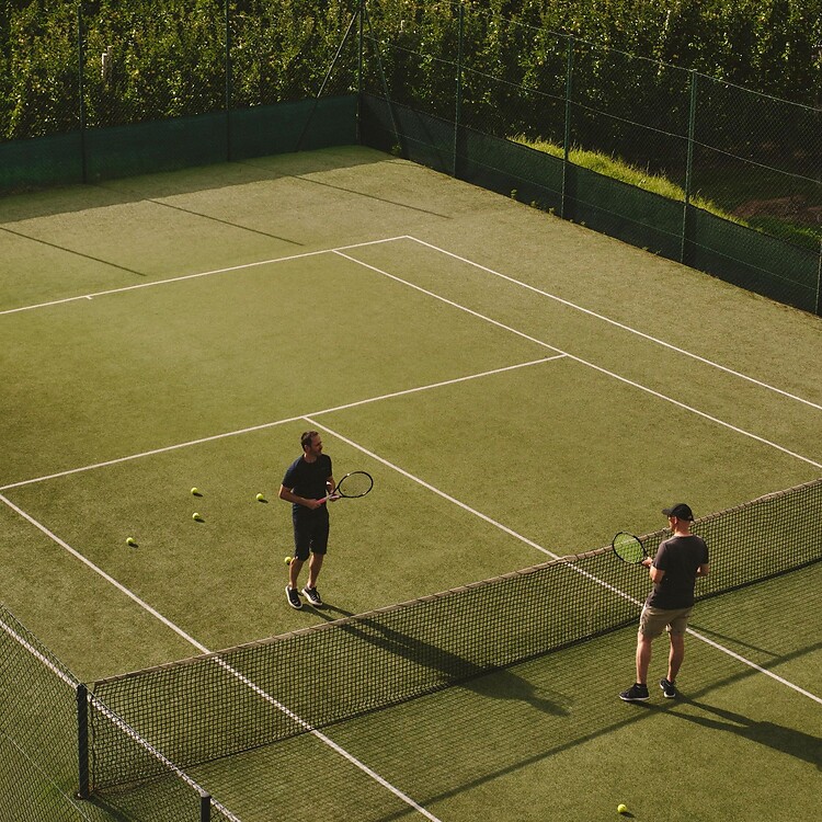 Hotel-owned tennis court surrounded by mountains