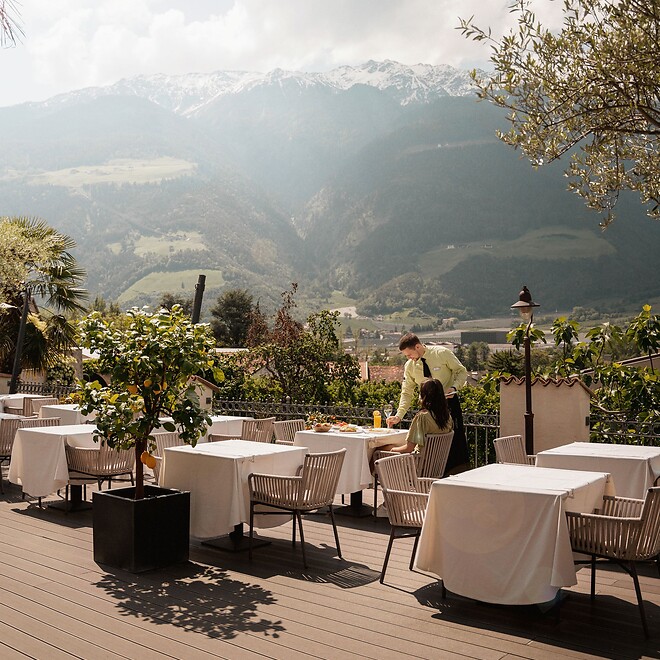 Kellner deckt die Tische auf der Sonnenterrasse ein