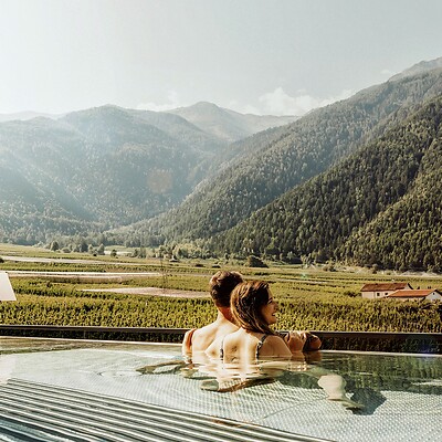 Frau und Mann im Rooftop Whirlpool mit Blick über die Apfelplantagen