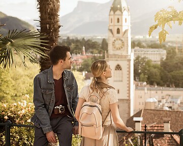Frau und Mann am Tappeinerweg mit Blick über die Stadt Meran