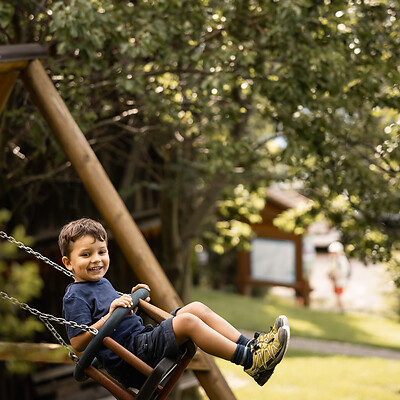 Kind beim Schaukeln auf dem Spielplatz in der Natur
