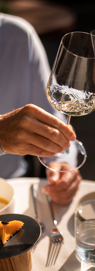 Uomo e donna gustano un bicchiere di vino durante un buon pasto.