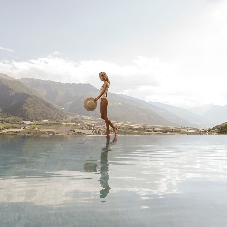 Donna che passeggia lungo l'Infinity Pool con vista panoramica