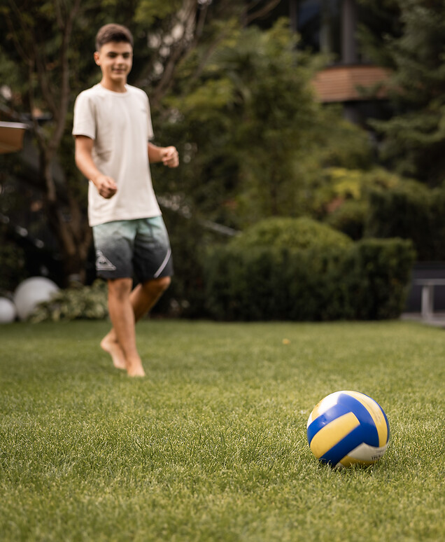 Boy playing with a ball in the garden