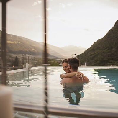 Coppia che si rilassa in una romantica piscina salina al tramonto.