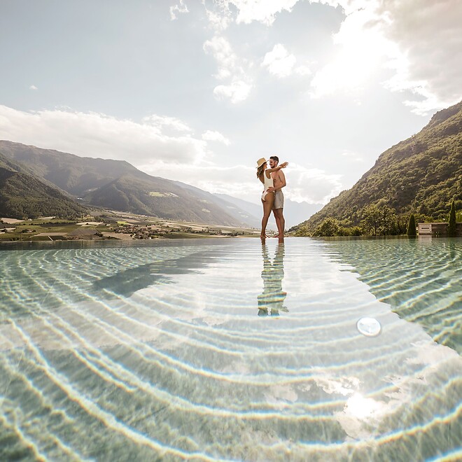 Frau und Mann umarmen sich im Sky Infinity Pool des Adults Only Hotels Preidlhof