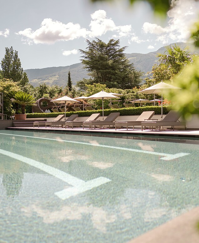 Sportpool mit Sonnenliegen im grünen Hotelgarten