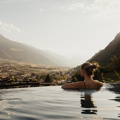 Frau im Sky Infinity Pool und blickt über das sonnenverwöhnte Tal