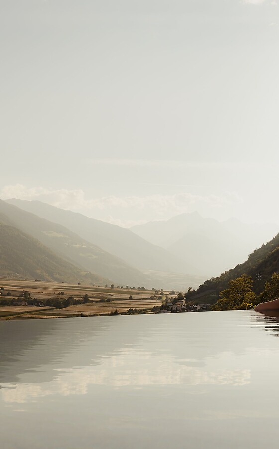 Woman in the infinity pool looking over the wide valley