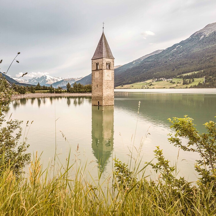 Versunkener Turm im Reschensee vor Bergkulisse