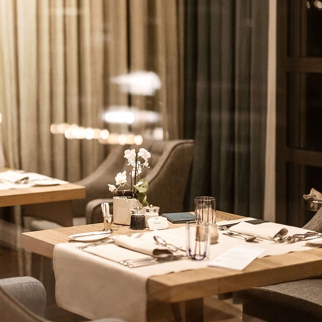 Gedeckte Restauranttische bei Nacht mit romantischer Beleuchtung 