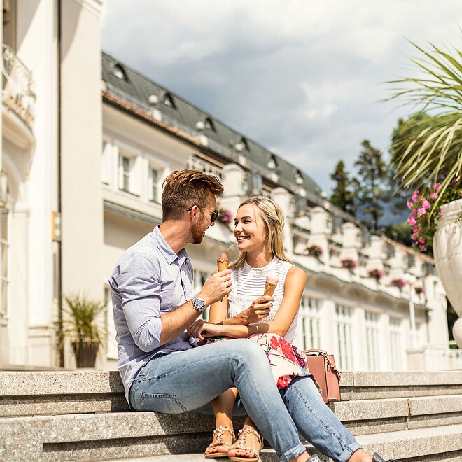 Mann und Frau genießen ein Eis vor dem Kurhaus in Meran