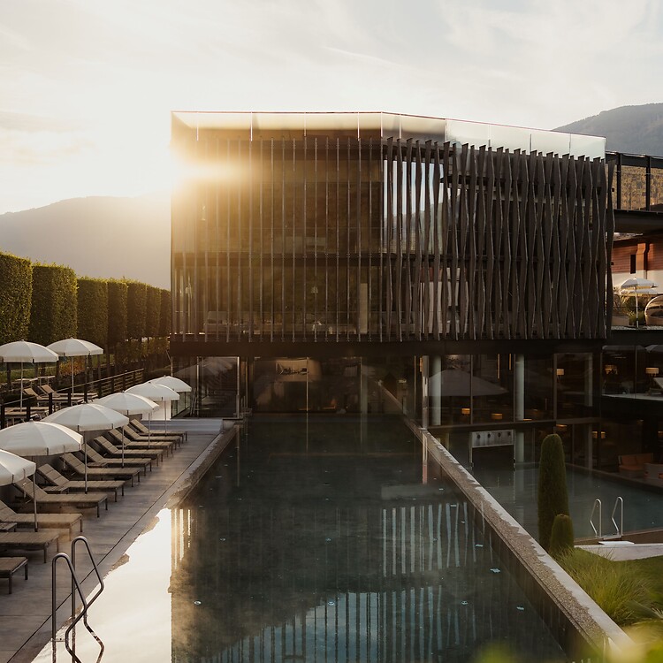 Wellnesstower con piscina sportiva e lettini prendisole all'alba