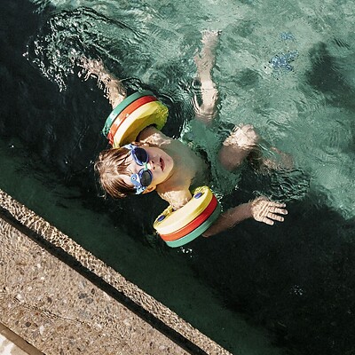 Kind schwimmt im Outdoor Thermalwasserpool