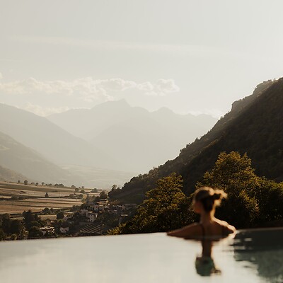 Frau im Infinity Sky Pool blickt auf das Bergpanorama