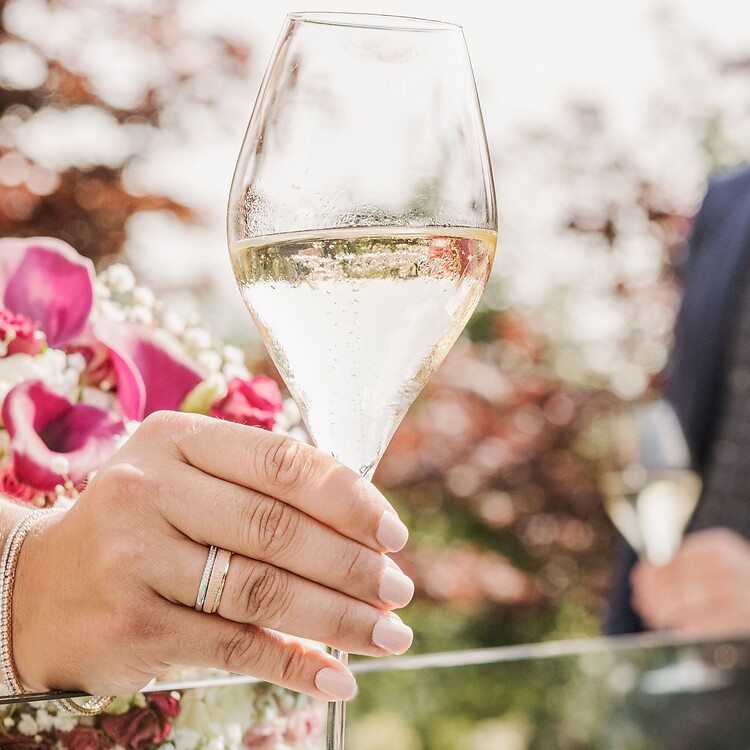 Man and woman in wedding attire at champagne reception